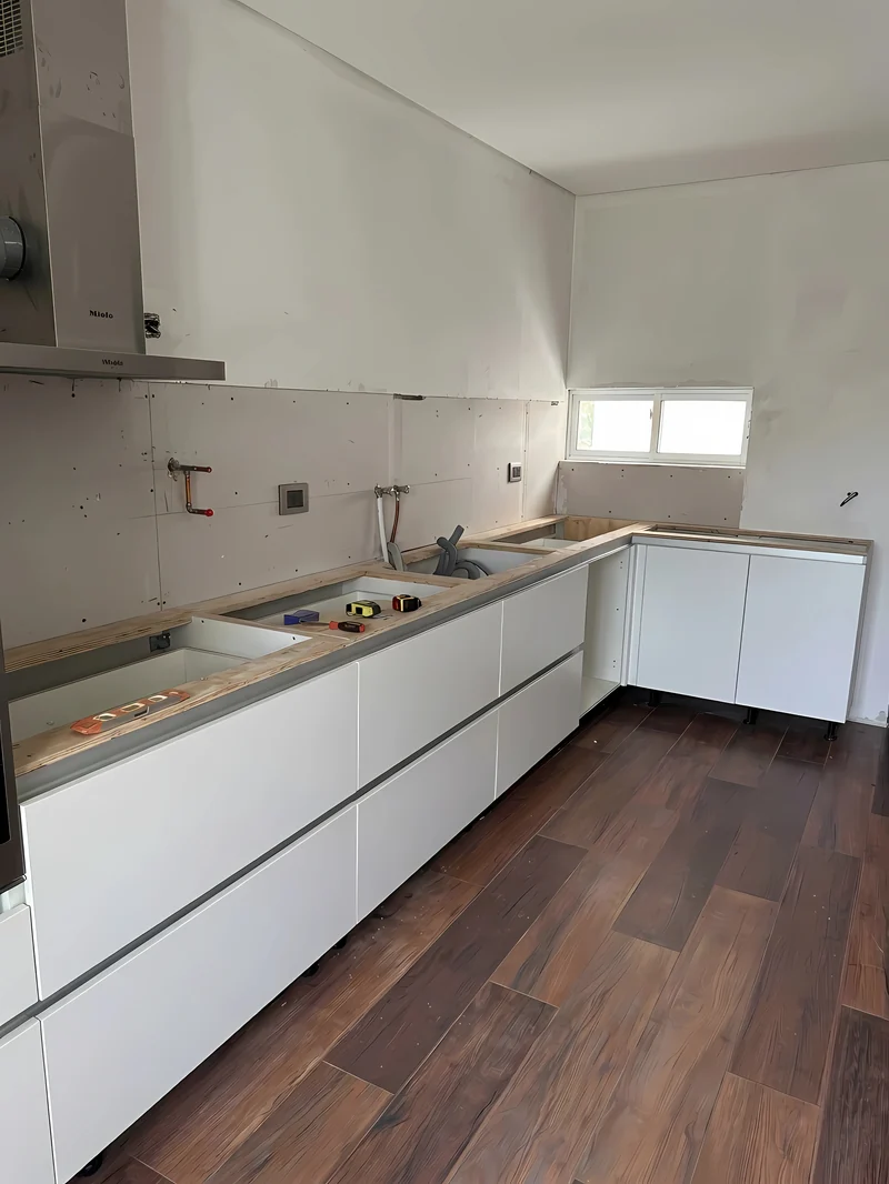 La cocina en obra: los muebles bajomesada colocados y las plantillas de madera sobre el mueble, todavía sin mesada