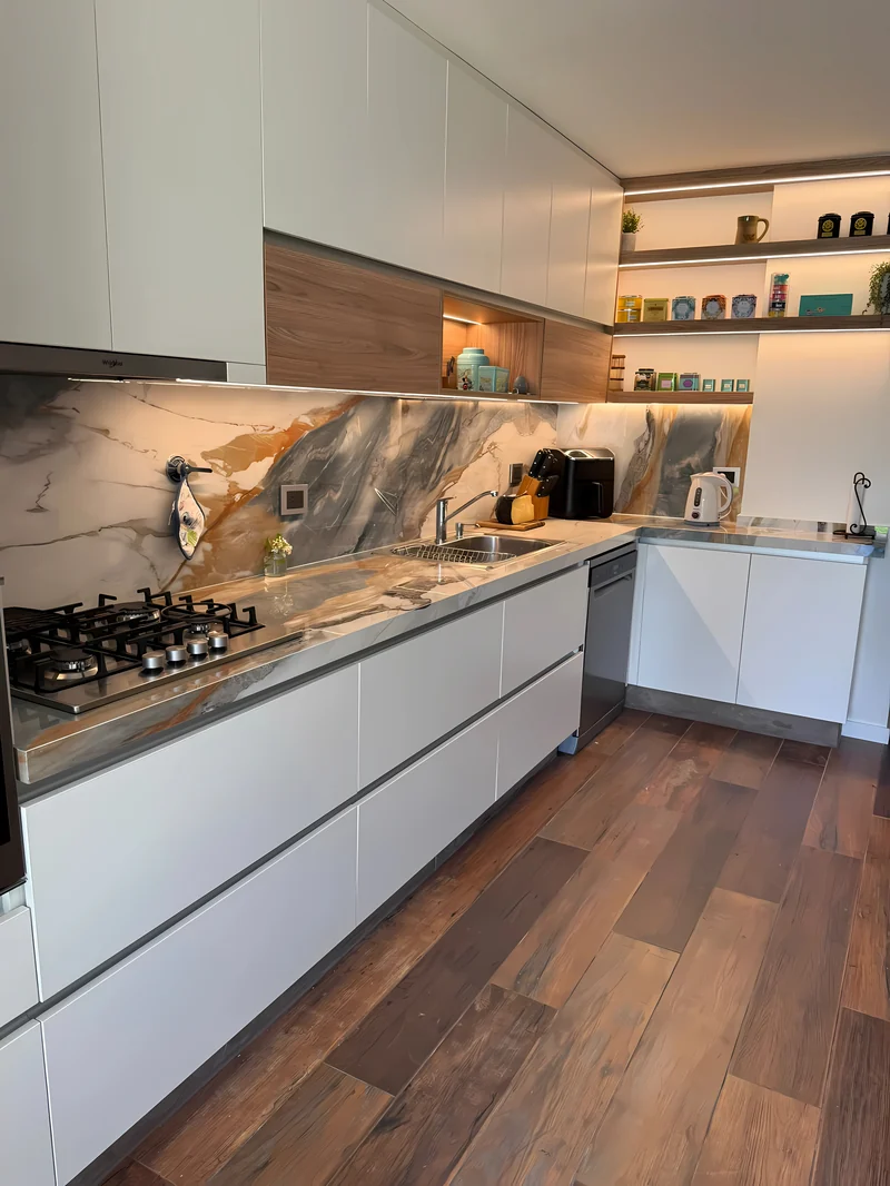 La misma cocina terminada, con la mesada y el salpicadero en piedra veteada de vetas ocres