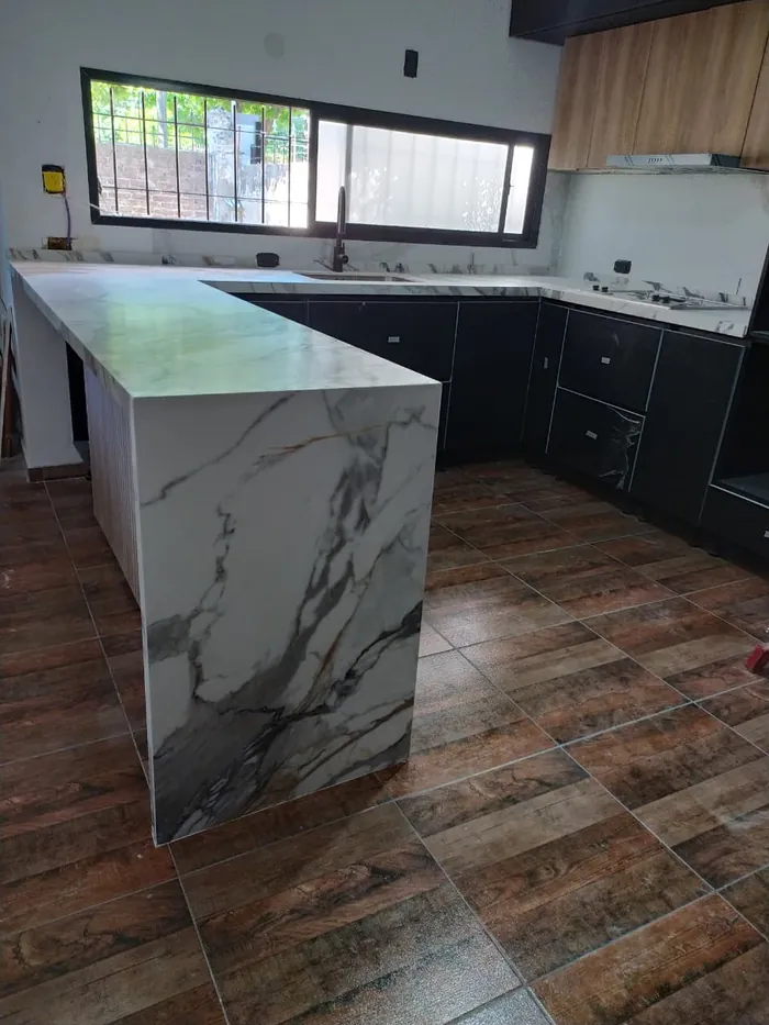 Isla de cocina en calacatta con caída a piso, sobre piso de madera