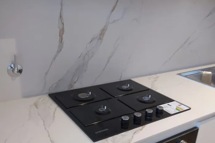 Mesada de cocina en calacatta con anafe a gas y horno empotrado
